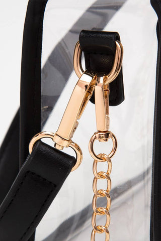 Gold chain strap attachment on a black handbag with a white background
