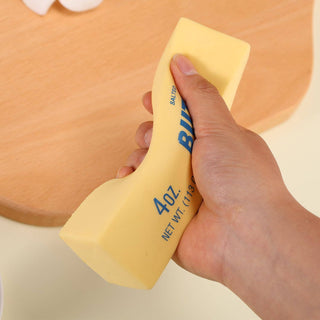 Hand holding a yellow bottle labeled 'Burt's Bees' with a beige background