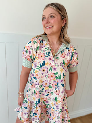 Woman wearing a floral dress with a white wall background