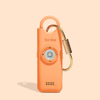 Orange device with a carabiner on a beige background