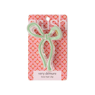 Green bow hair clip on a patterned pink and white card with 'very demure' text