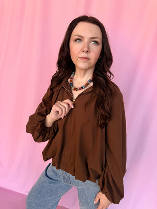 girl wearing a brown shirt on a pink background 