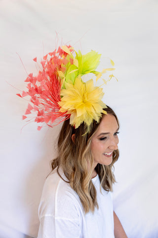 Woman wearing a colorful floral headpiece against a white background