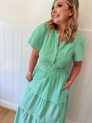 Woman wearing a green dress with a white wall background