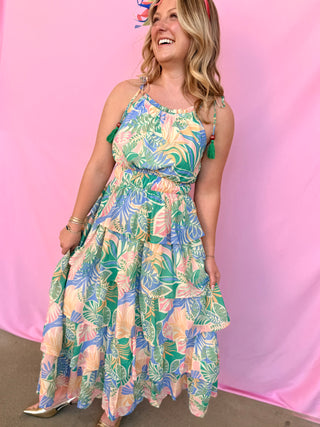 Woman wearing a colorful floral dress against a pink background