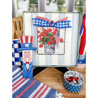 Decorative patriotic items including a candy dish, Uncle Sam figure, and floral arrangement on a table.