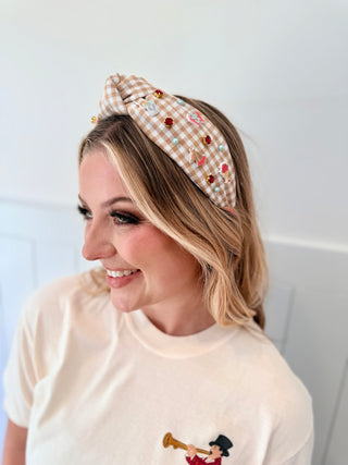 Woman wearing a decorative headband with a plain background
