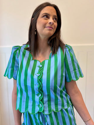 Woman wearing a green and blue striped dress against a white background