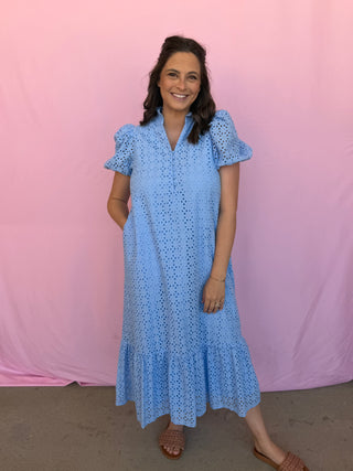 Woman wearing a blue dress with a pink background