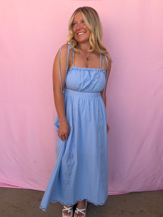 Woman wearing a light blue dress against a pink background