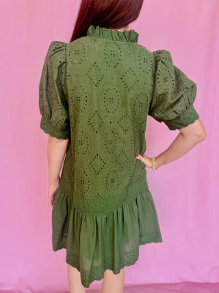woman wearing a green dress on a pink background