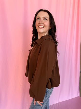 girl wearing a brown shirt on a pink background 