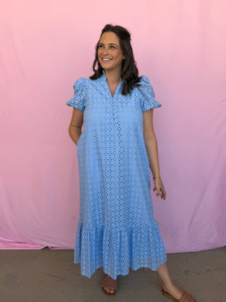 Woman wearing a blue dress with a pink background