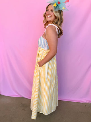 Woman wearing a striped dress with a colorful headband against a pink background