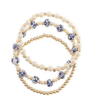 Set of three beaded bracelets with blue floral patterns on a white background