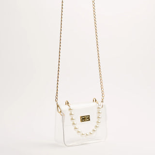 White handbag with gold chain strap on a light gray background