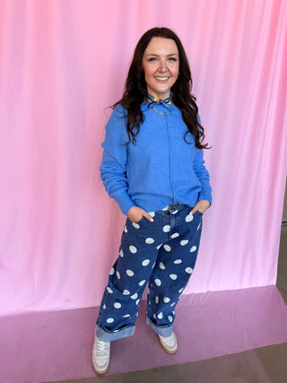 girl wearing blue sweater on a pink background