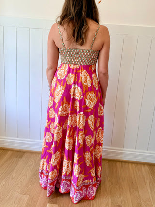Woman wearing a floral dress with a white paneled wall background