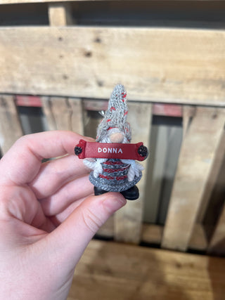 Small decorative item with 'DONNA' on it held by a hand against a wooden background
