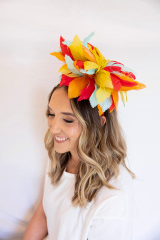 Woman wearing a colorful headpiece against a white background