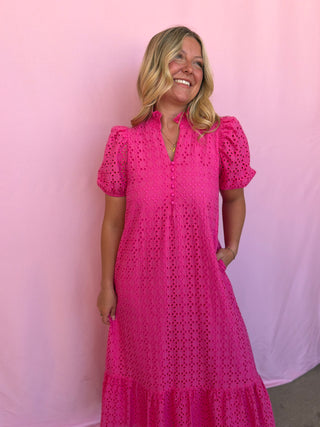 Woman wearing a pink dress against a pink background