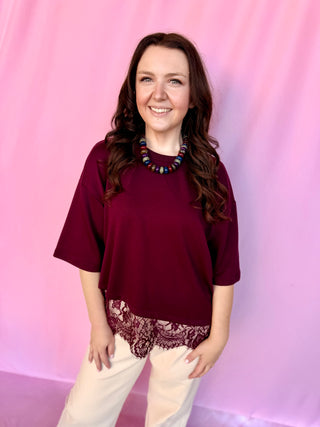 girl wearing red top on a pink background 