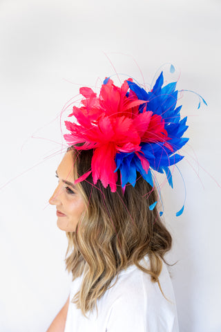 Woman wearing a colorful feathered headpiece against a white background