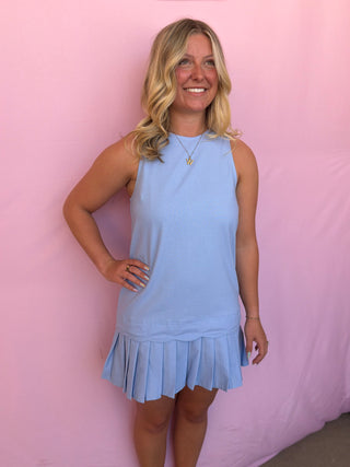 Woman wearing a light blue dress against a pink background