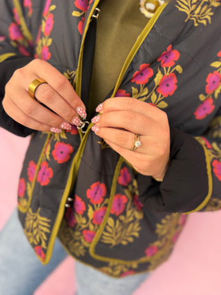 Person wearing a floral-patterned jacket with a pink background