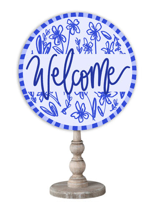 Decorative sign with 'Welcome' text and floral designs on a white background