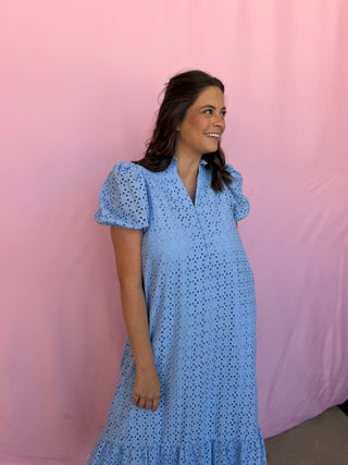 Woman wearing a blue dress with a pink background