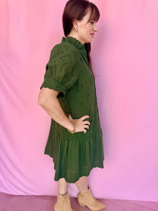 woman wearing a green dress on a pink background