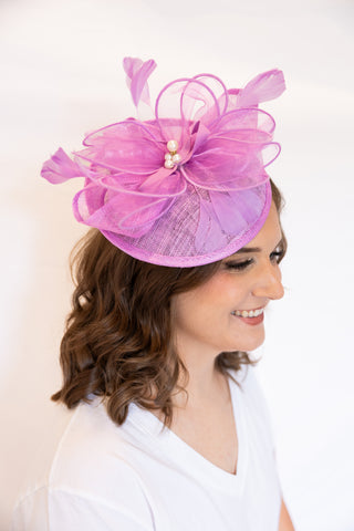 Woman wearing a pink floral headpiece against a white background