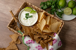 Tortilla chips with a bowl of dip on a wooden table