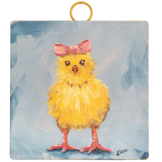 Painting of a yellow chick with a pink bow on a blue background