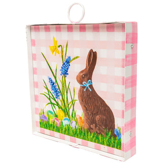 Easter-themed gift box with a chocolate bunny and floral design on a pink and white checkered background.