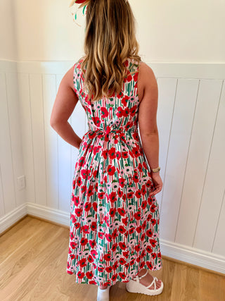 Woman wearing a floral dress with a white wall background