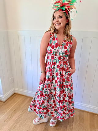 Woman wearing a floral dress and colorful headpiece indoors.