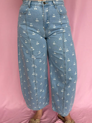 Person wearing blue jeans with a subtle pattern on a pink background