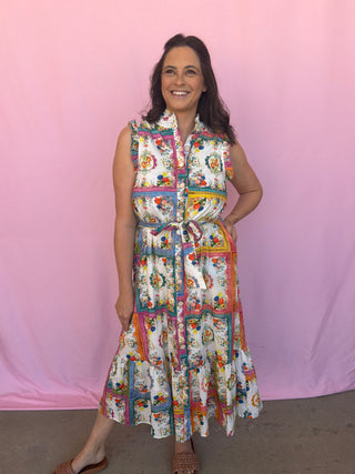 Woman wearing a colorful patterned dress against a pink background