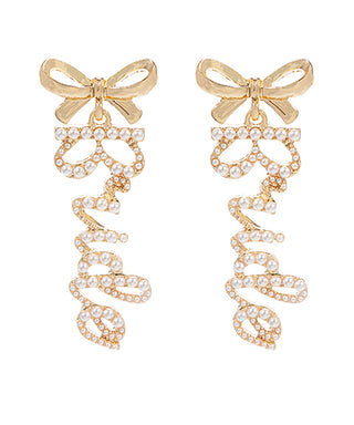Gold bow earrings with pearl details on a white background