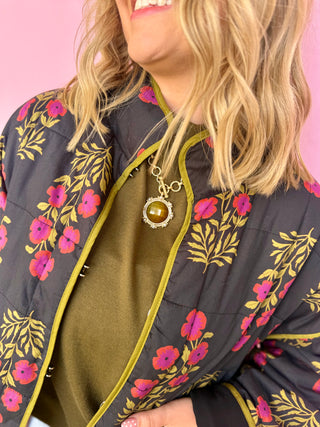 Person wearing a floral-patterned jacket with a pink background