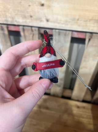 Small red and gray toy car with 'JOSEPH' on a wooden surface