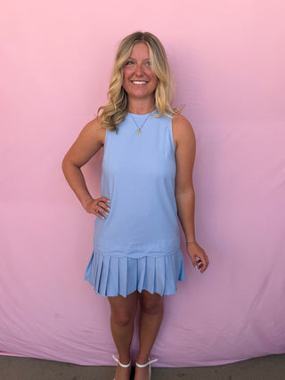 Woman wearing a light blue dress against a pink background