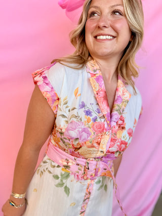 Woman wearing a floral dress against a pink background