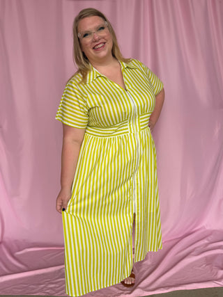 Woman wearing a yellow and white striped dress against a pink background