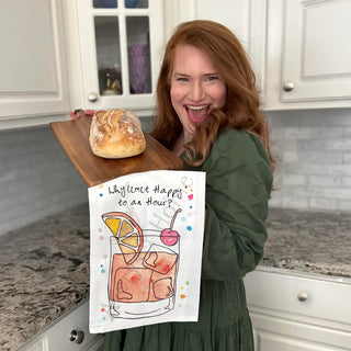 Woman holding a loaf of bread and a towel with a drink illustration in a kitchen.