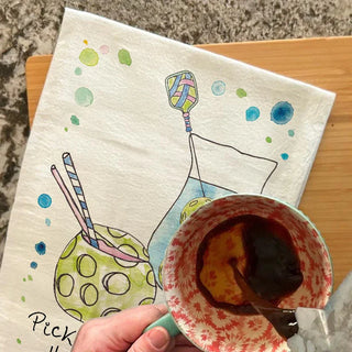 Napkin with a colorful drawing of a drink and a hand holding a cup with a spoon.