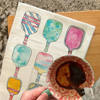 Colorful illustrations of paddles on a towel with a bowl of ice cream.