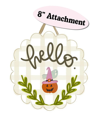 A scalloped white and beige gingham hanging sign with the word “hello” in dark brown script, decorated with a small orange jack-o'-lantern wearing a pink witch hat, a gray ghost, and green leafy branches. A pink oval label at the top reads “8” Attachment.